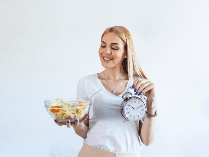 Woman on an intermittent fast holding a clock